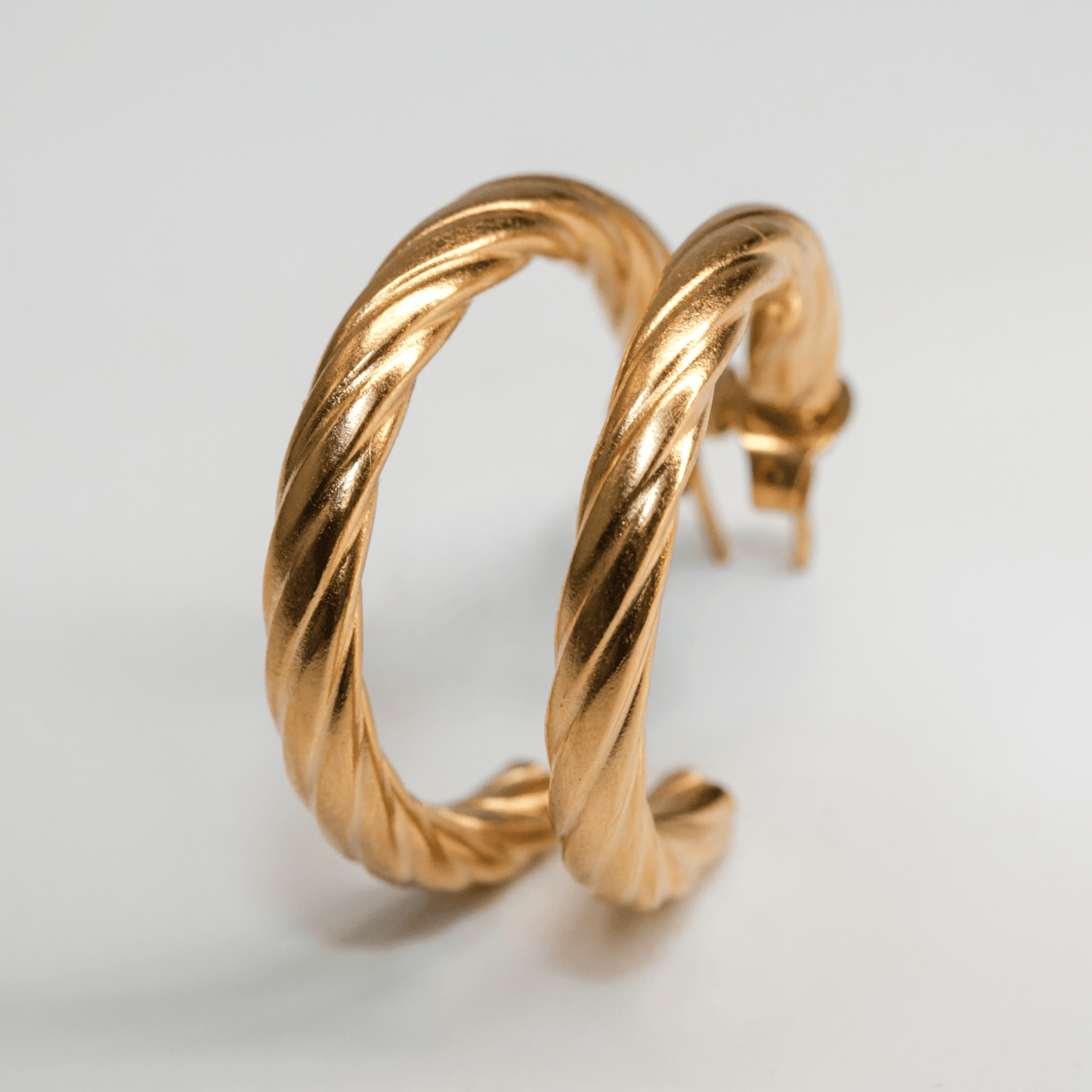 Vera Twist Hoops gold earrings with sculpted swirling texture and subtle shine