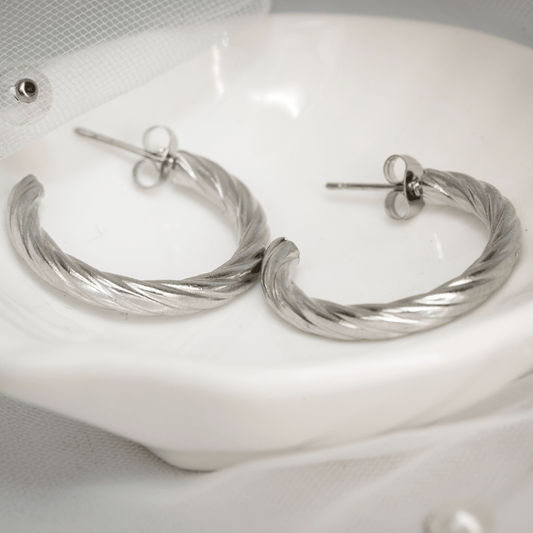 Silver Vera Twist Hoops with smooth reflective texture and graceful curves