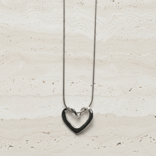 The Unity Heart Necklace, Silver open-heart pendant necklace with sleek, curved silhouette on chain.