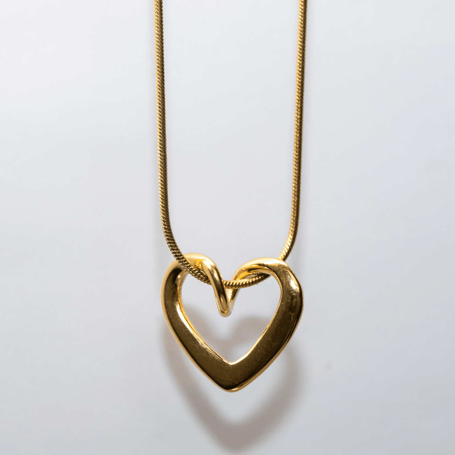 Gold Unity Heart Necklace with smooth sculptural curve and modern romantic design