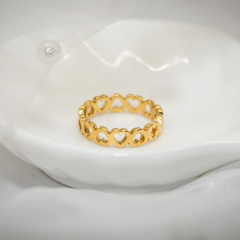 Gold heart ring on white dish